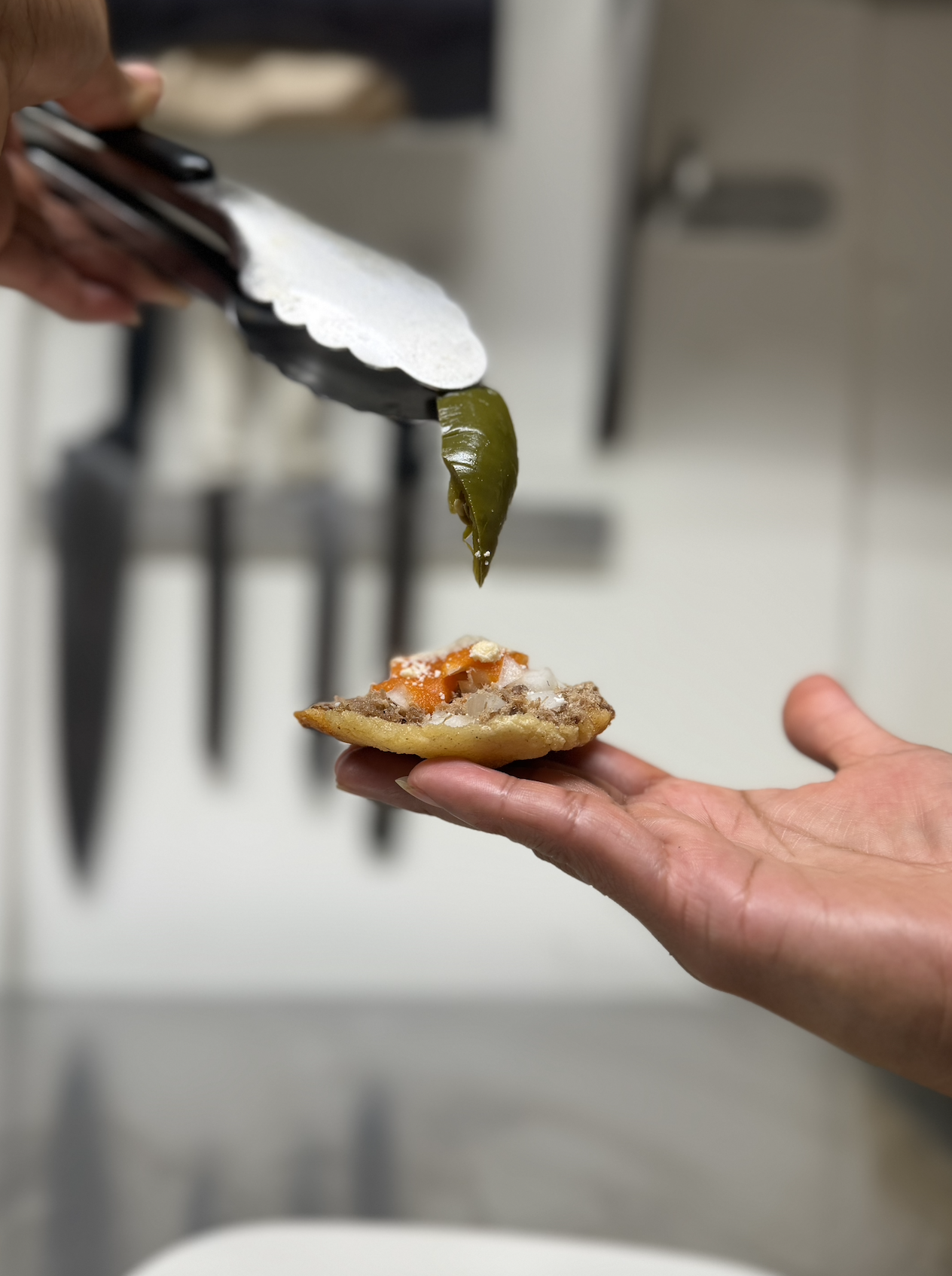 Una mano sosteniendo una garnacha con jalapeño